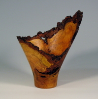 A wooden vase with brown and black wood grain.