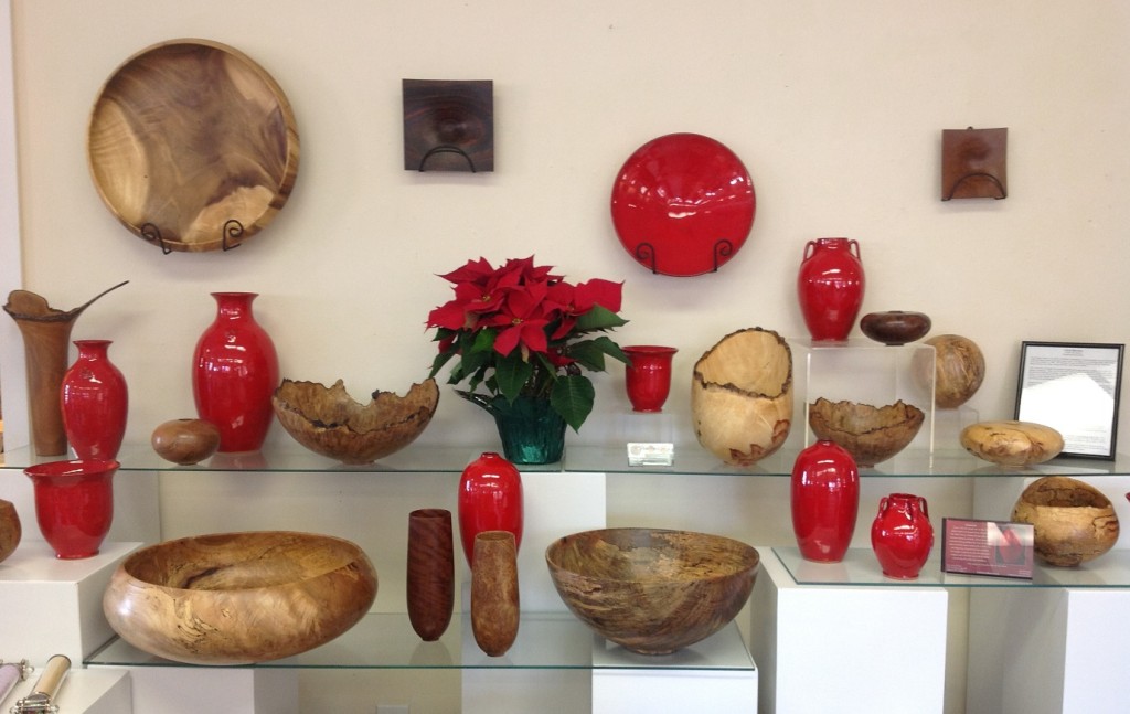 A display of red vases and bowls on shelves.