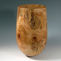 A wooden vase with a tree trunk pattern.